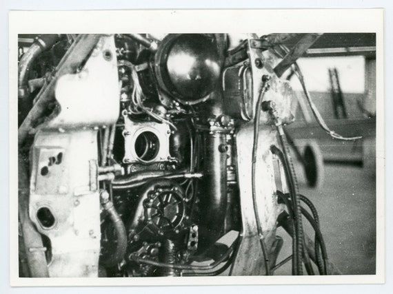 Zwart-witfoto van een opengewerkte vliegtuigmotor in een archiefdocument