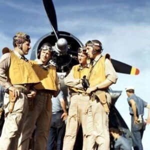 Vier bemanningsleden in uniform bij een historisch vliegtuig